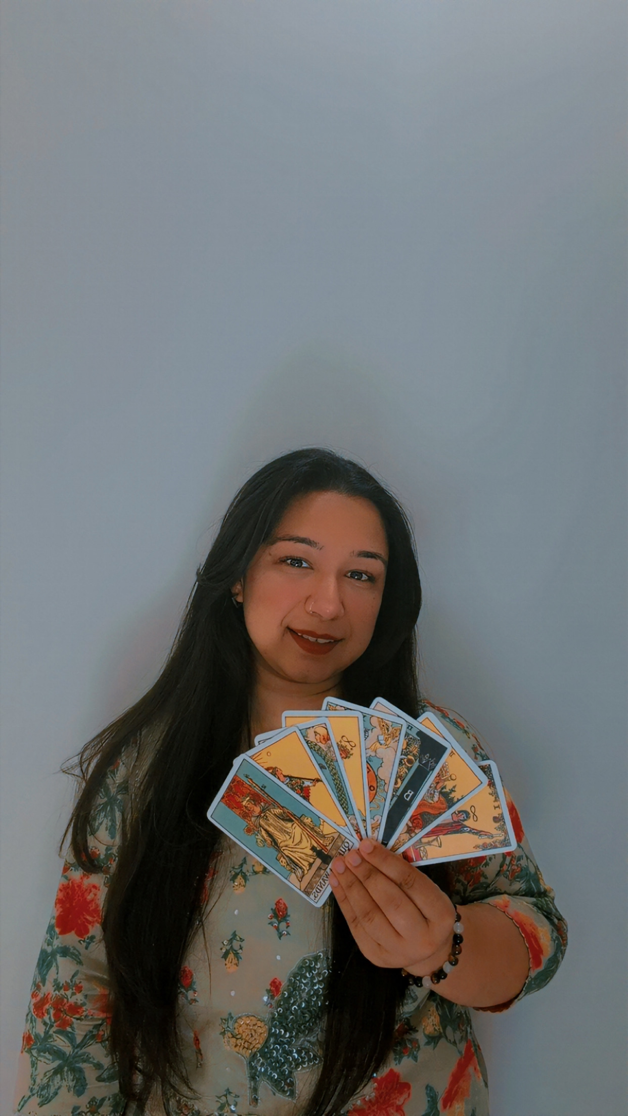Shivi holding a fan of tarot cards